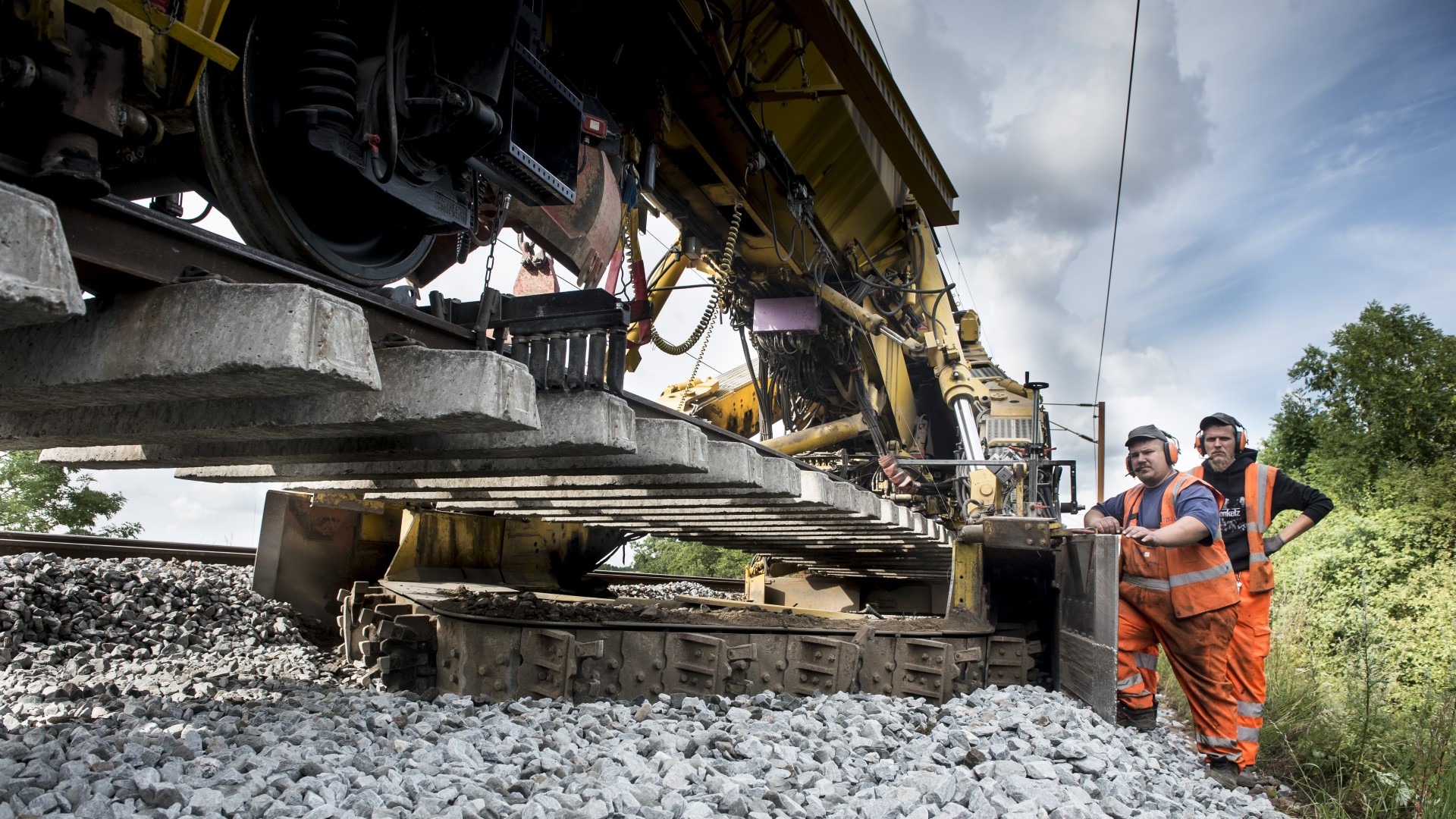 Workers at big yellow machine